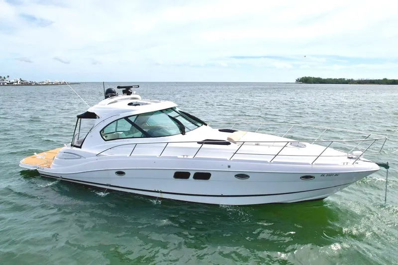 The Image of A sleek white motorboat cruising on calm waters, featuring a spacious deck and modern windows. - 0