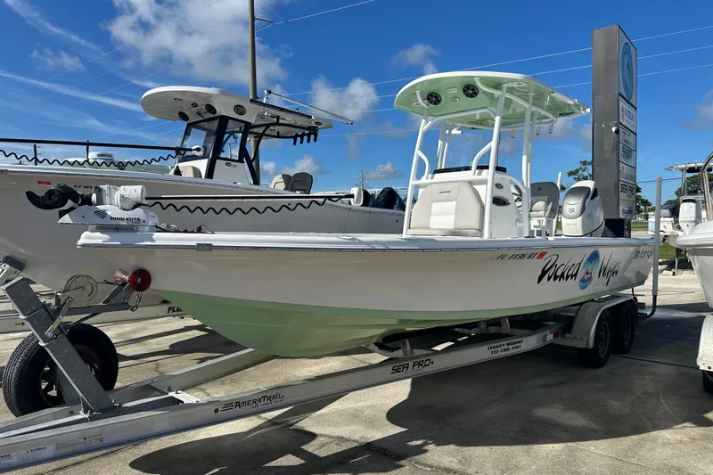 Slide: The Image of 2018 Sea Pro 248 Bay boat on trailer under clear blue sky. - 2