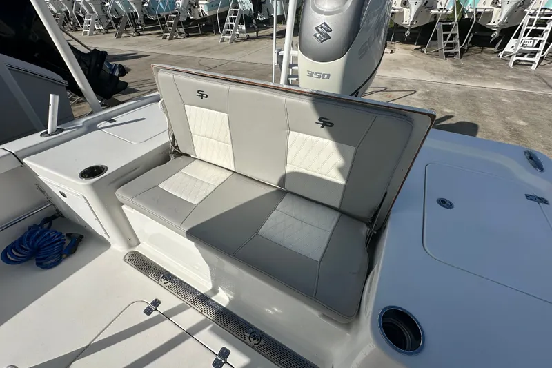 Slide: The Image of 2018 Sea Pro 248 Bay boat interior with cushioned seating and Suzuki 350 engine. - 18