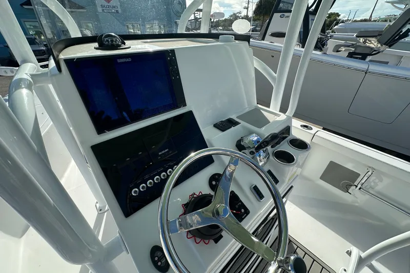 Slide: The Image of 2018 Sea Pro 248 Bay boat dashboard with steering wheel and navigation screens. - 7