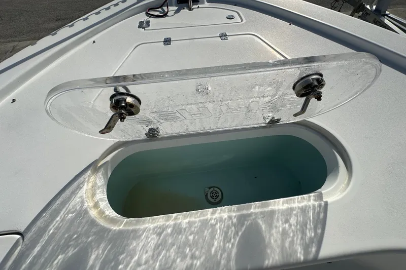 Slide: The Image of Livewell on 2018 Sea Pro 248 Bay boat, open lid, sunlight reflecting on water. - 11