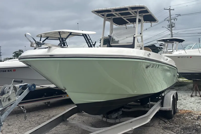 Slide: The Image of 2025 Bayliner Trophy T22CC boat on trailer, parked outdoors under cloudy sky. - 3