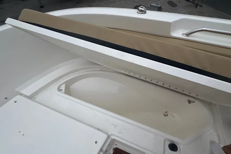Slide: The Image of 2025 Bayliner Trophy T22CC boat interior with storage compartment and cushioned seating. - 17
