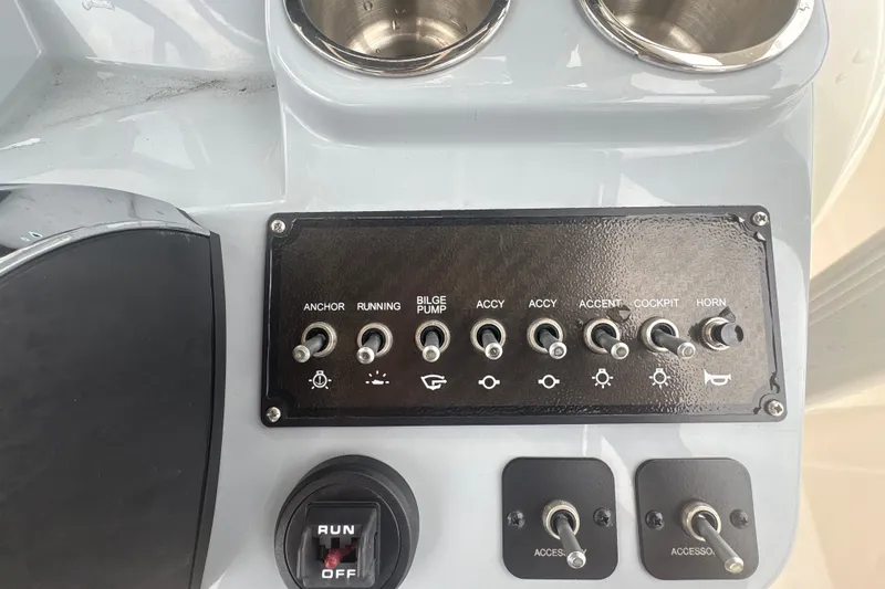 Slide: The Image of Control panel of 2025 Bayliner Trophy T22CC boat with switches and cup holders. - 10