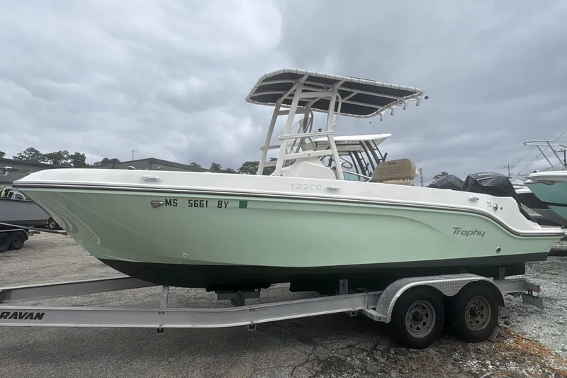 The Image of 2025 Bayliner Trophy T22CC boat on trailer, overcast sky background. - 0