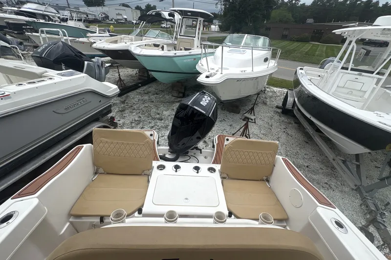 Slide: The Image of 2025 Bayliner Trophy T22CC boat with outboard motor, surrounded by other boats in a lot. - 20