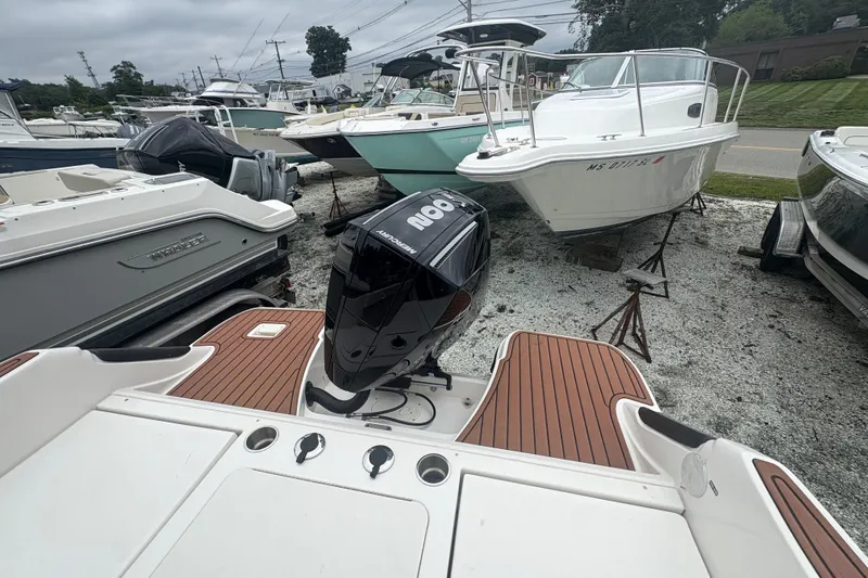 Slide: The Image of 2025 Bayliner Trophy T22CC boat with outboard motor, displayed in a marina. - 6