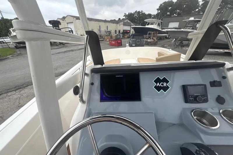Slide: The Image of 2025 Bayliner Trophy T22CC boat dashboard with steering wheel and navigation equipment. - 12