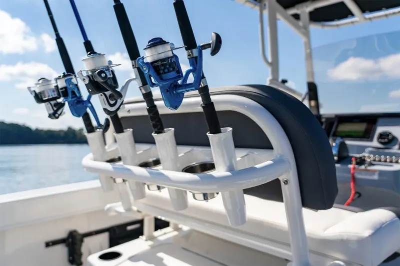 Slide: The Image of Manufacturer Provided Image: 2025 Bayliner Trophy T22CC fishing rods on boat, sunny day, lake view. - 32