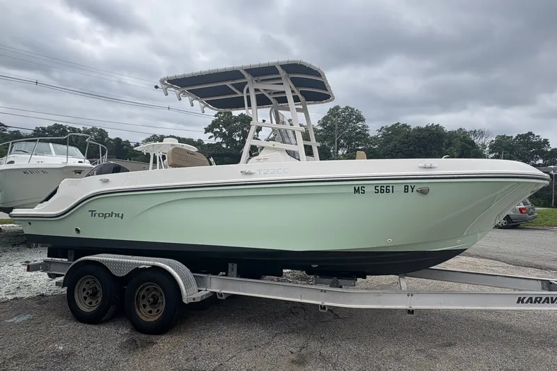 Slide: The Image of 2025 Bayliner Trophy T22CC boat on trailer, overcast sky background. - 1