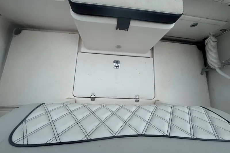 Slide: The Image of Interior view of a 2011 Donzi 29 ZF Open boat, featuring white seating and storage. - 21