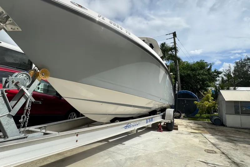 Slide: The Image of 2011 Donzi 29 ZF Open boat on trailer, parked outdoors under a cloudy sky. - 14