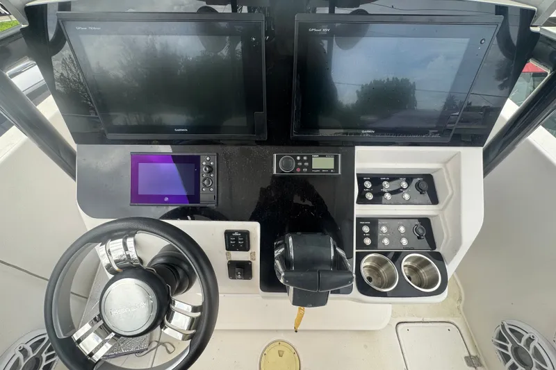 Slide: The Image of 2011 Donzi 29 ZF Open boat dashboard with steering wheel, controls, and dual Garmin displays. - 27