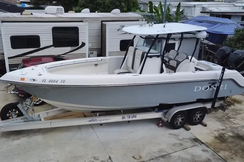 Slide: The Image of 2011 Donzi 29 ZF Open boat on trailer, parked near RVs. - 4