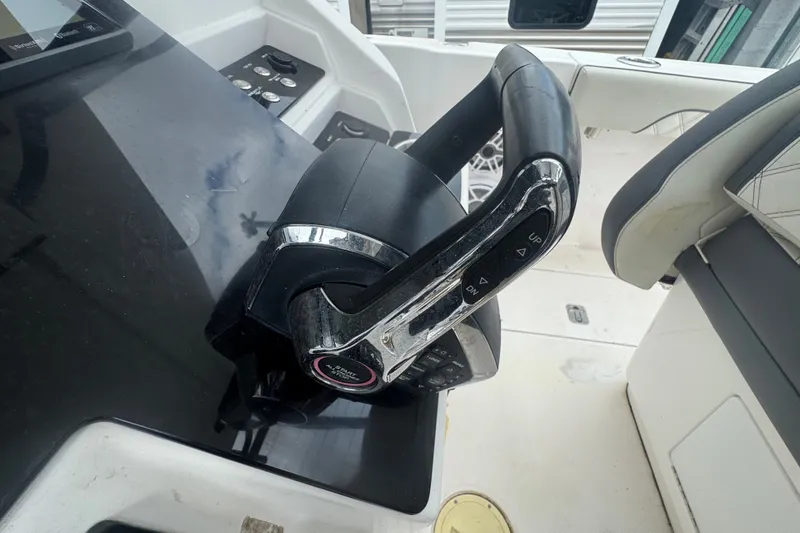 Slide: The Image of Steering wheel of a 2011 Donzi 29 ZF Open boat, featuring control buttons. - 34