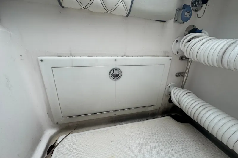 Slide: The Image of 2011 Donzi 29 ZF Open boat compartment with coiled hoses and storage hatch. - 22