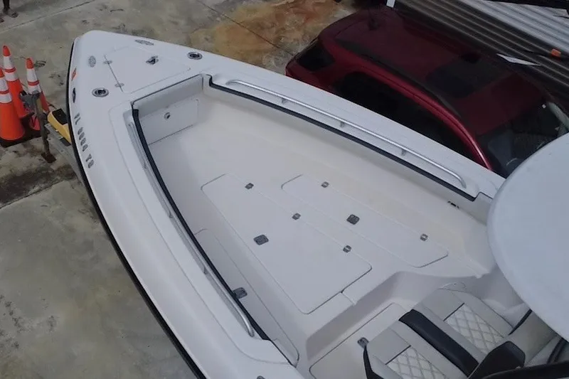 Slide: The Image of 2011 Donzi 29 ZF Open boat, aerial view, docked beside a red vehicle. - 16