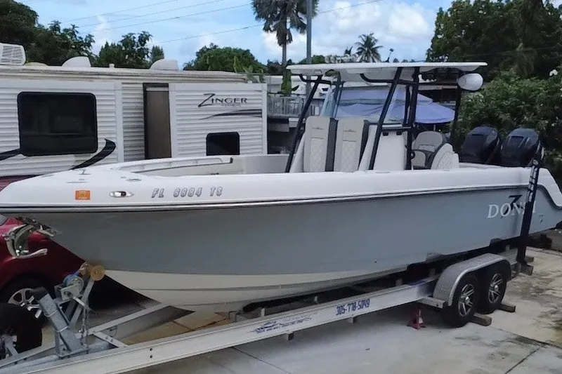 Slide: The Image of 2011 Donzi 29 ZF Open boat on trailer, parked near RV and trees. - 5