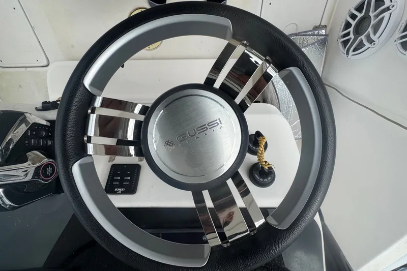 Slide: The Image of Steering wheel of a 2011 Donzi 29 ZF Open boat, featuring sleek metallic design. - 33