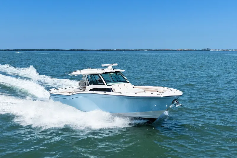Slide: The Image of 2023 Grady-White Canyon 456 boat cruising on open water under clear blue sky. - 14