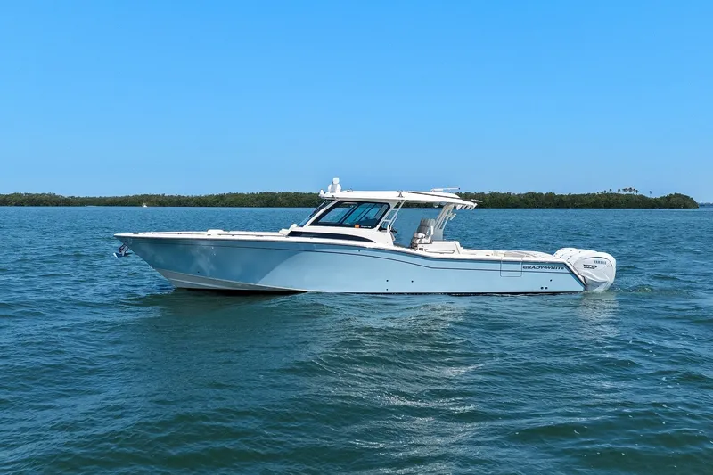 Slide: The Image of 2023 Grady-White Canyon 456 boat cruising on open water under clear blue sky. - 10