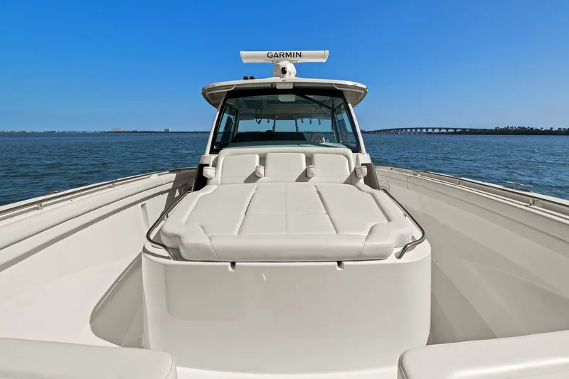 Slide: The Image of 2023 Grady-White Canyon 456 boat on open water, featuring spacious deck and Garmin equipment. - 65