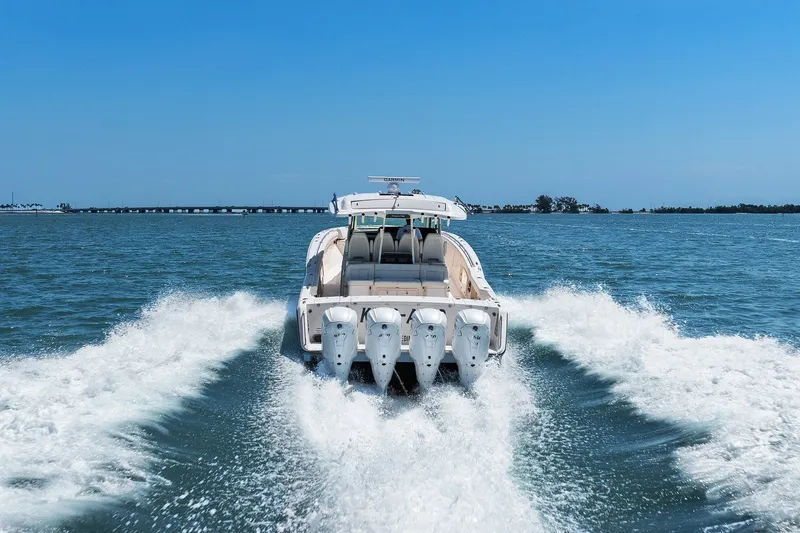 Slide: The Image of 2023 Grady-White Canyon 456 boat cruising on open water, rear view. - 19