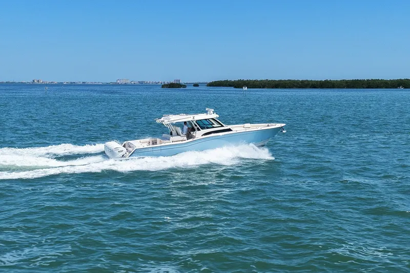 Slide: The Image of 2023 Grady-White Canyon 456 cruising on open water under clear blue skies. - 13