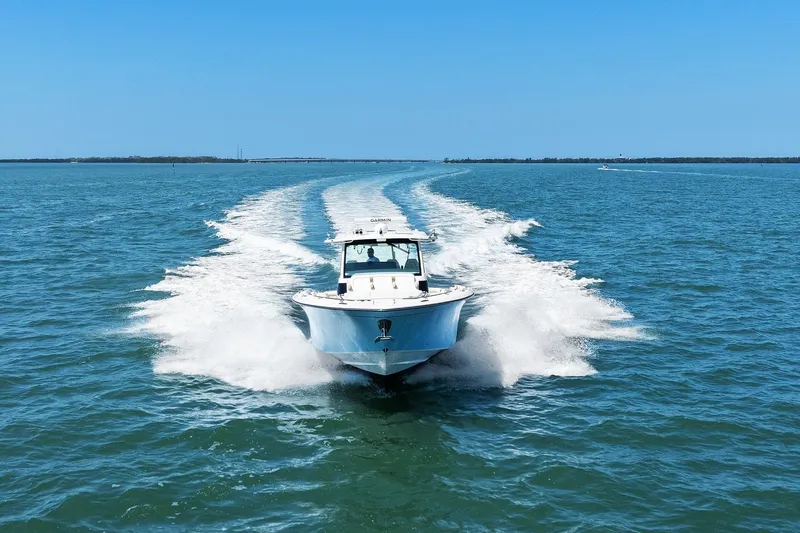 Slide: The Image of 2023 Grady-White Canyon 456 boat cruising on open water under clear blue skies. - 15