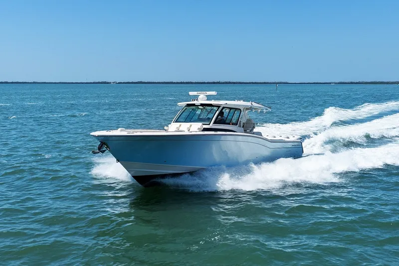 Slide: The Image of 2023 Grady-White Canyon 456 cruising on open water under clear blue skies. - 17
