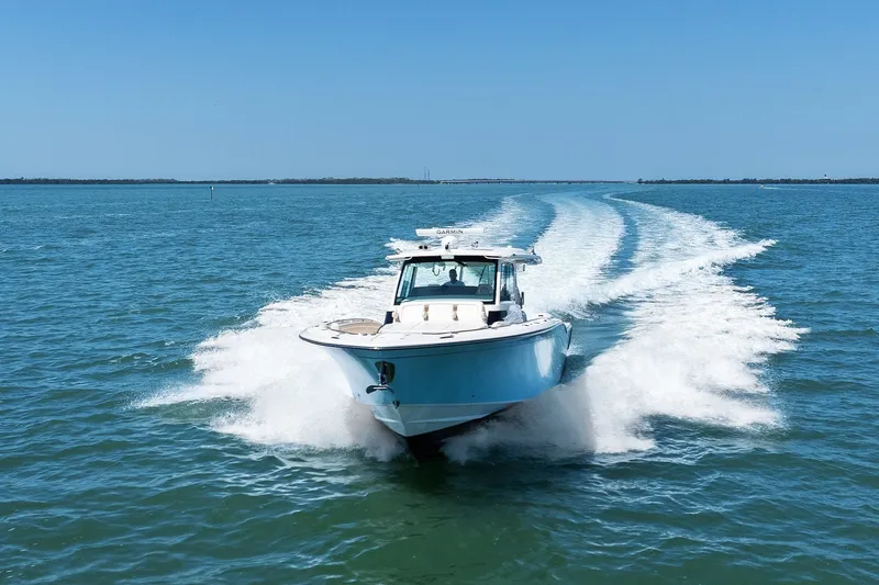 Slide: The Image of 2023 Grady-White Canyon 456 boat cruising on open water under clear blue sky. - 18