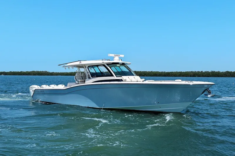 Slide: The Image of 2023 Grady-White Canyon 456 boat cruising on open water under clear blue sky. - 12