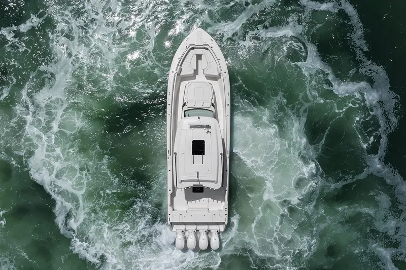 Slide: The Image of Aerial view of 2023 Grady-White Canyon 456 boat navigating through swirling ocean waters. - 26