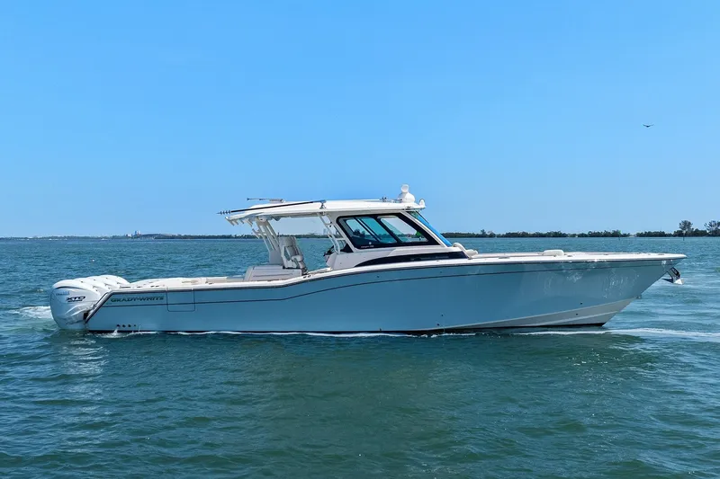 Slide: The Image of 2023 Grady-White Canyon 456 boat cruising on open water under clear blue sky. - 1