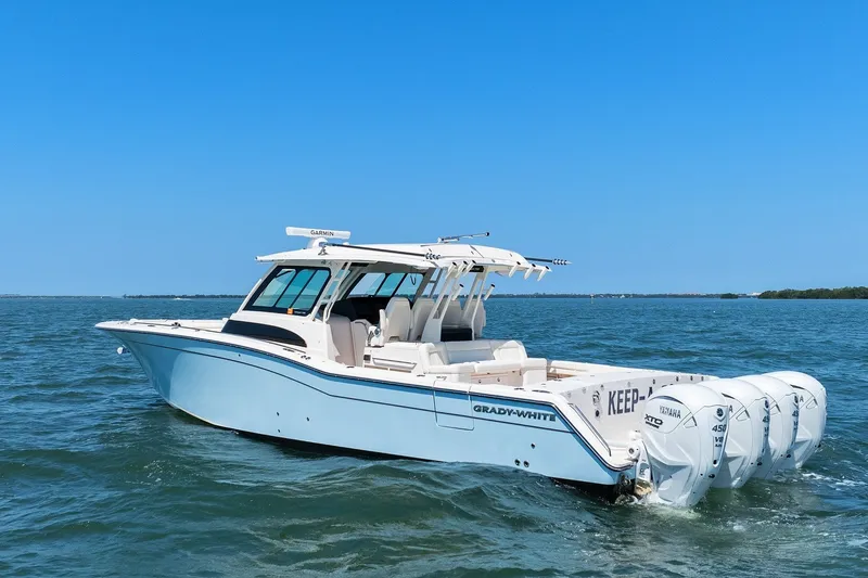 Slide: The Image of 2023 Grady-White Canyon 456 boat on open water, featuring multiple outboard engines. - 3