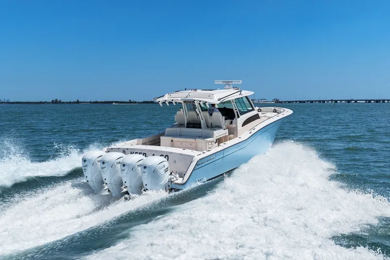 Slide: The Image of 2023 Grady-White Canyon 456 boat cruising on open water, showcasing powerful engines. - 21