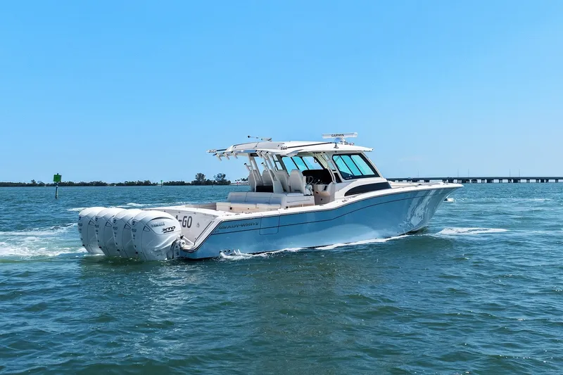 Slide: The Image of 2023 Grady-White Canyon 456 boat cruising on open water under clear blue sky. - 11