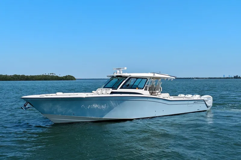 Slide: The Image of 2023 Grady-White Canyon 456 boat cruising on open water under clear blue sky. - 5