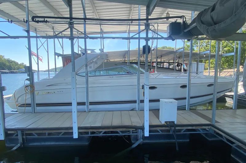 Slide: The Image of 2000 Formula 400 Super Sport boat docked under a covered marina. - 0