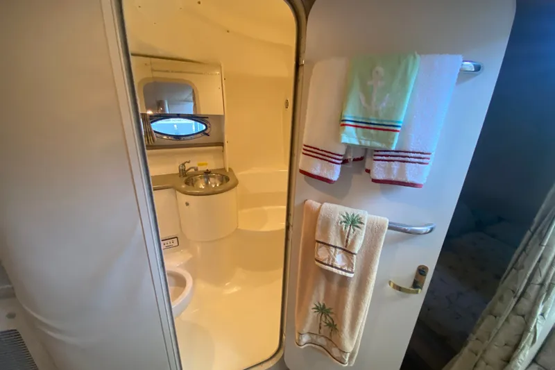 Slide: The Image of Bathroom interior of a 2000 Formula 400 Super Sport boat, featuring towels and a sink. - 44
