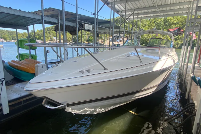 Slide: The Image of 2000 Formula 400 Super Sport boat docked in a marina, surrounded by water and greenery. - 5