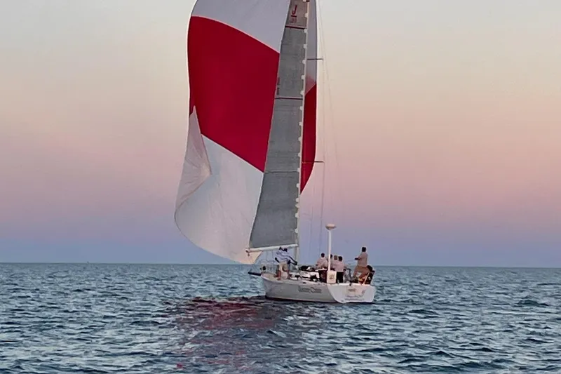 Slide: The Image of Sailing J Boats J/120, 2002 model, at sunset with red and white spinnaker. - 4