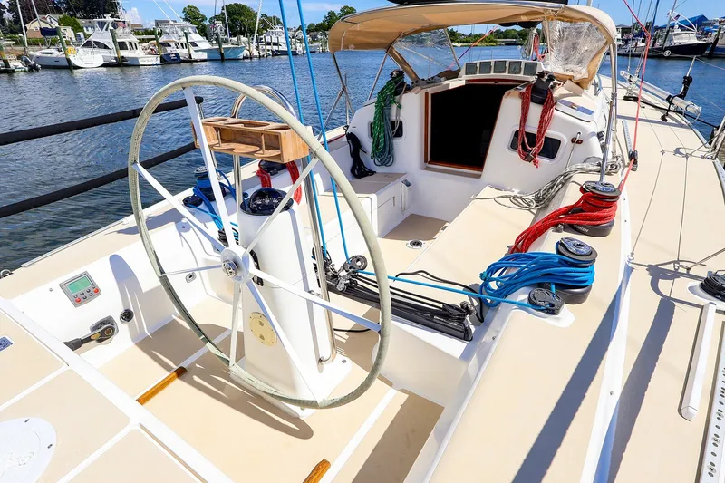 Slide: The Image of 2002 J Boats J/120 sailboat cockpit with steering wheel and colorful ropes docked at marina. - 17