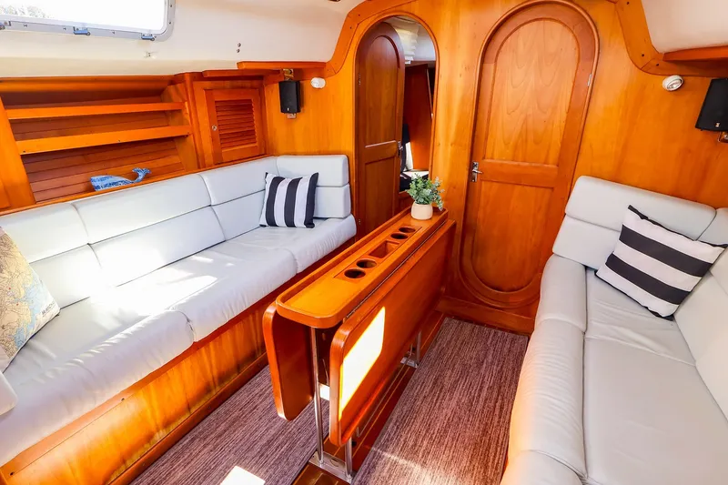 Slide: The Image of Interior of 2002 J Boats J/120 sailboat with cozy seating and wooden finishes. - 49