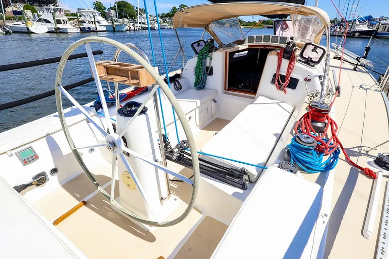 Slide: The Image of 2002 J Boats J/120 sailboat cockpit with steering wheel and ropes, docked at marina. - 12