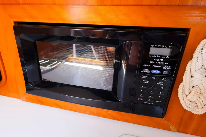 Slide: The Image of Microwave in 2002 J Boats J/120 yacht galley, featuring wood paneling and nautical rope. - 44