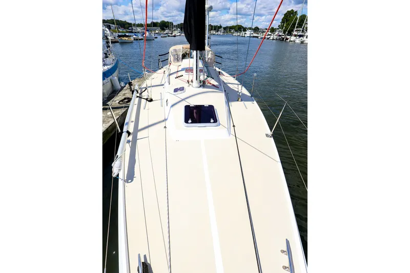 Slide: The Image of 2002 J Boats J/120 sailboat docked in a marina, showcasing its sleek deck design. - 7