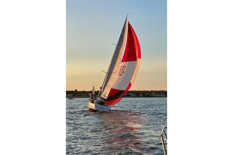 Slide: The Image of Sailing J Boats J/120, 2002 model, with vibrant spinnaker at sunset on calm waters. - 5