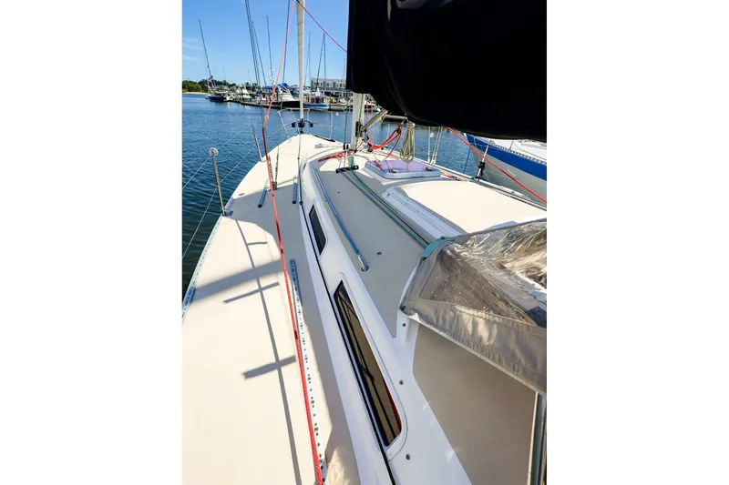 Slide: The Image of 2002 J Boats J/120 sailboat deck view, docked in a marina under clear blue skies. - 10