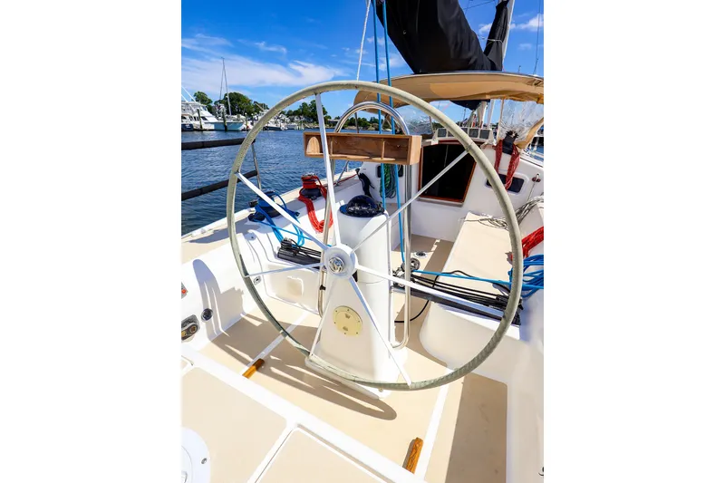Slide: The Image of 2002 J Boats J/120 sailboat cockpit with steering wheel, docked under clear blue sky. - 19